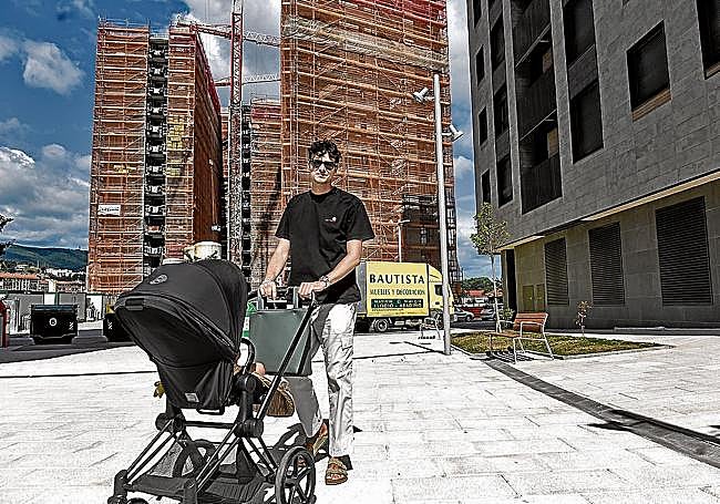 Rubén pasea a la pequeña Nora. En segundo plano, la obra de la promoción vecina, de pisos tasados.