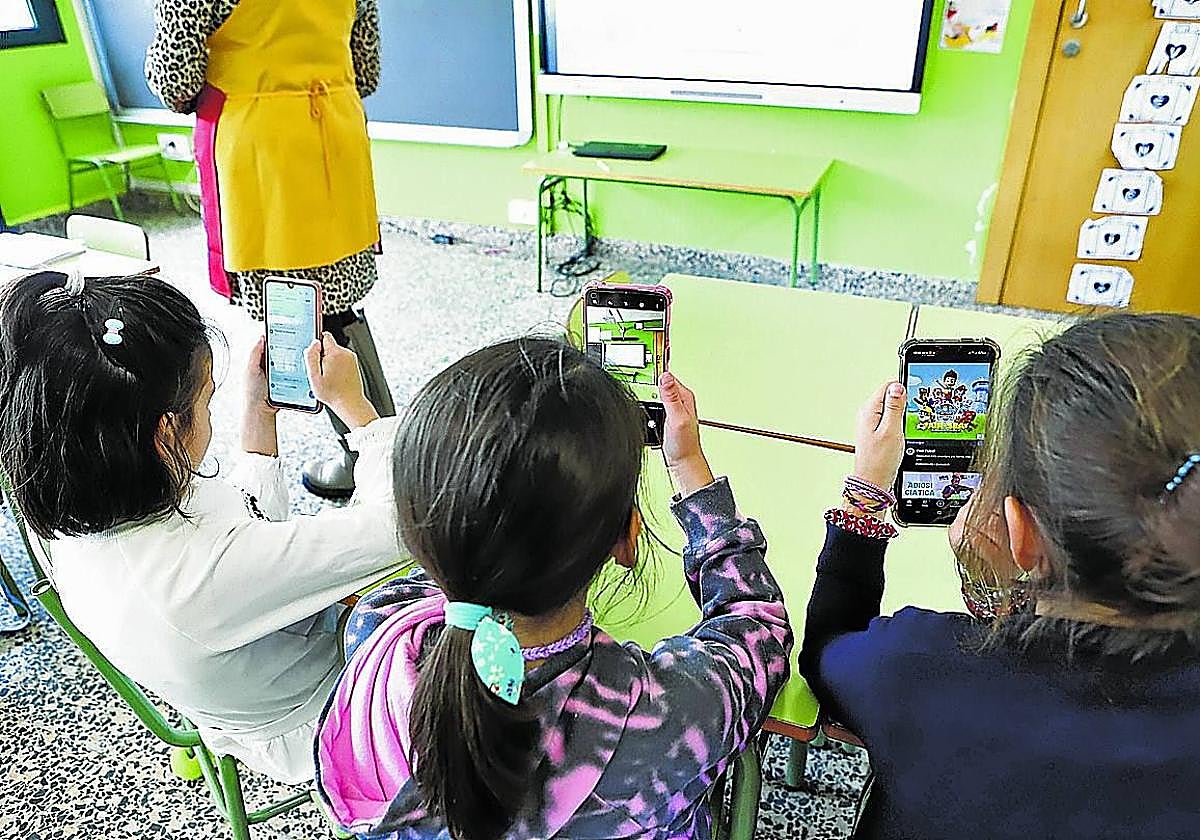 Alumnos de Infantil pendientes del teléfono móvil en el aula.