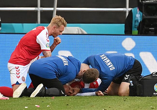 Los servicios médicos de la seleccióndanesa atienden a Eriksen tras su desmayo en el campo en el partido de la Eurocopa de 2021 contra Finlandia.