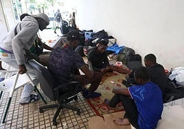 Un grupo de malienses mata el tiempo jugando a las cartas en los soportales donde están asentados en la plaza Cofradías Donostiarra (San Sebastián).