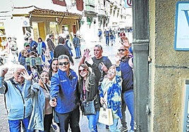 Turistas se hacen un selfie junto al portal de una vivienda turística en el Casco Viejo de Bilbao.