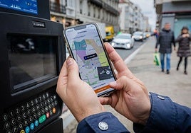 Una persona paga la OTA en Vitoria a traves de la aplicación móvil.