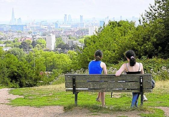 Dos jóvenes disfrutan de la panorámica desde este espacio que por ley carece de cercados y edificaciones.
