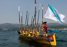 La tripulación de Orio saluda a la afición con los remos en alto tras imponerse en la Bandera de Boiro.