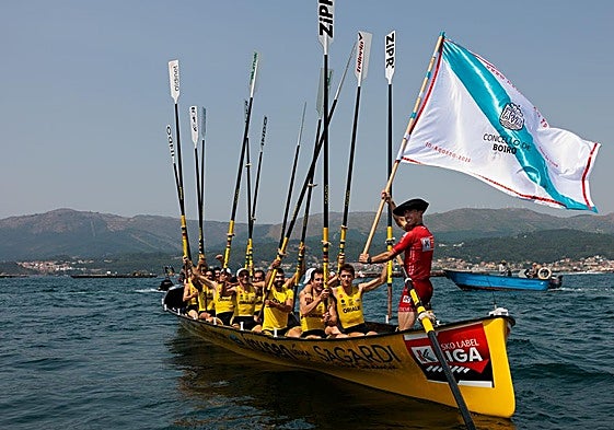 La tripulación de Orio saluda a la afición con los remos en alto tras imponerse en la Bandera de Boiro.