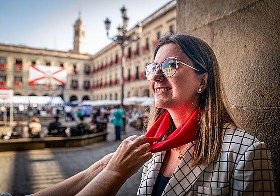 La concejala socialista María Nanclares se coloca el pañuelo de fiestas en la plaza de España.
