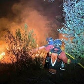 Dos agentes de la Unidad Militar de Emergencias (UME) trabajan en las labores de extinción del incendio en Tres Cantos, Madrid.