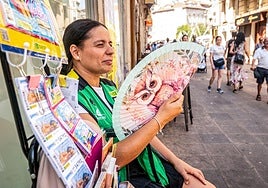 Ainara López, vendedora de la ONCE, se abanica en Postas.