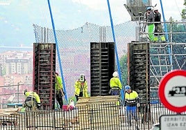 Empleados de la construcción trabajan en la obra de un edificio de una localidad vizcaína.