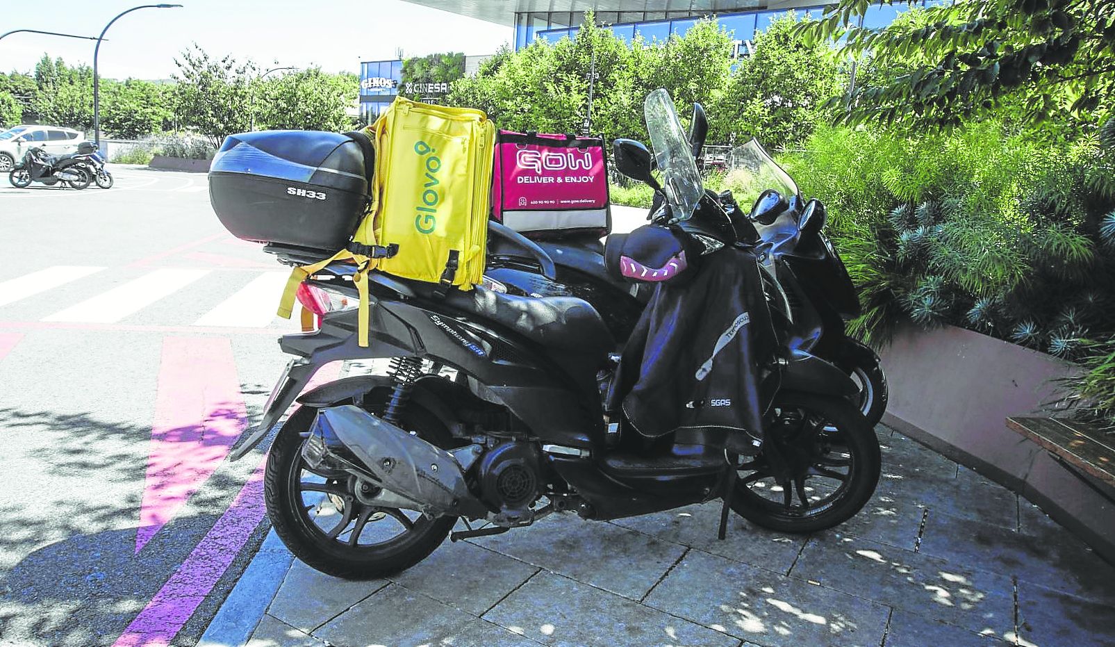 Una moto de Glovo aparcada en frente del centro comercial Garbera, donde opera Eroski.