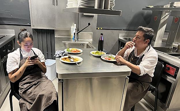 En torno a las 17.30 horas, después de haber concluido el servicio de comidas y de haber limpiado a fondo toda la cocina, los miembros del equipo, a medida que concluyen sus tareas, comen en la propia cocina. Hoy toca una ensalada de tomate, un guiso de lentejas, pimientos verdes y algo de la última tortilla que se elaboró por la mañana. En la foto, Ana consulta su teléfono y Fernando da cuenta de la ensalada.