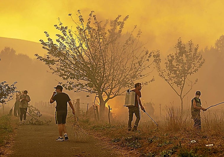 Vecinos combaten el fuego con los medios a su alcance en el municipio orensano de Carballeda de Avia.
