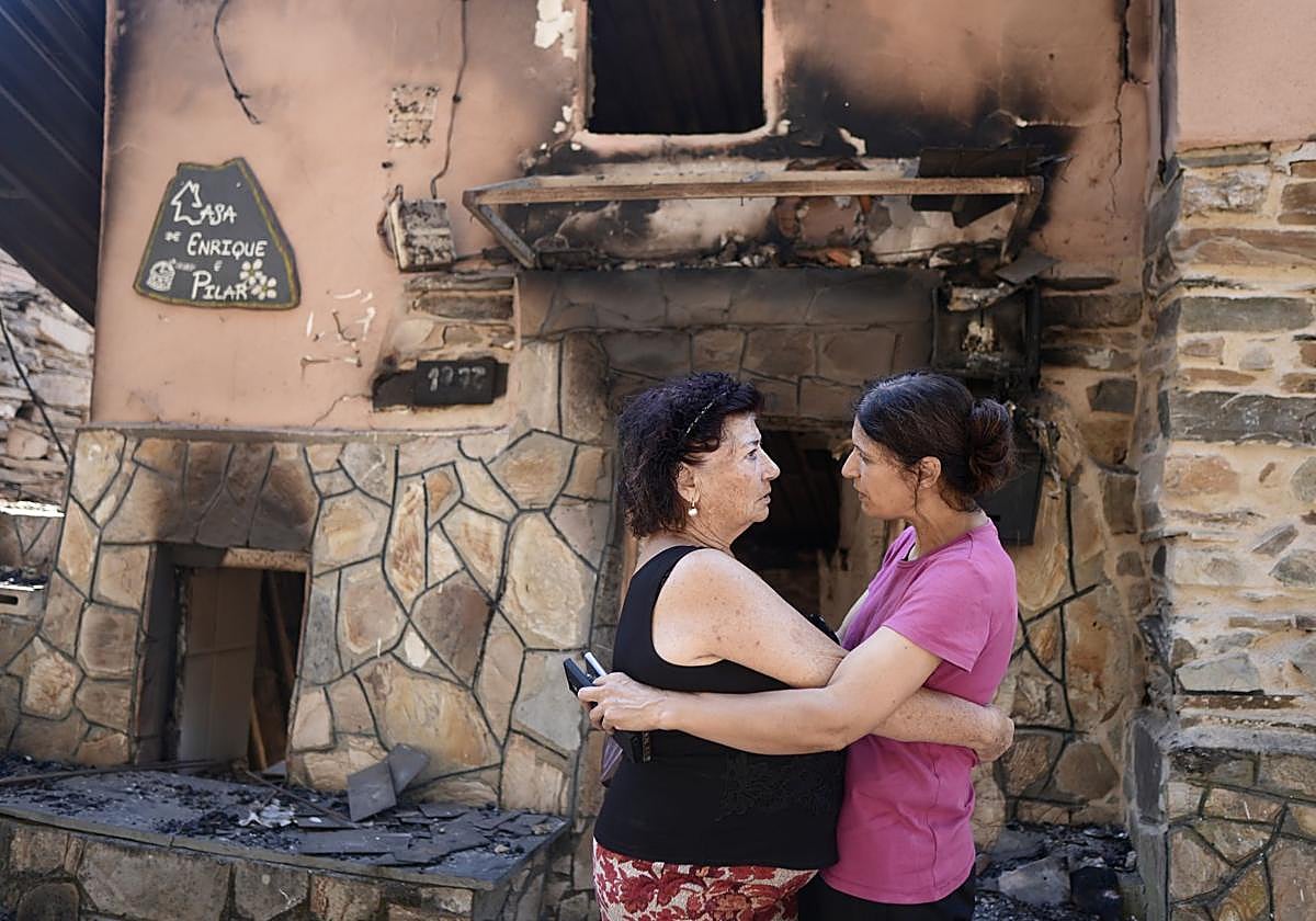 Dos vecinas se abrazan tras el incendio que ha asolado San Vicente de Leira, en Ourense.