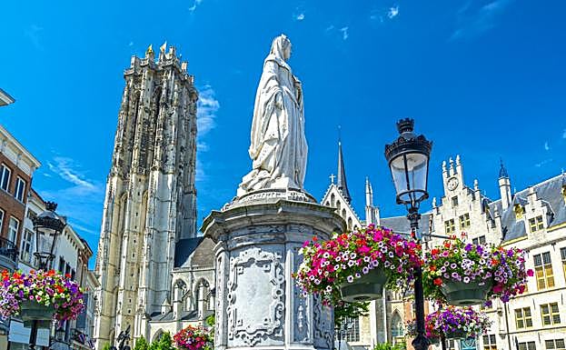 Escultura de Margarita de Austria ante la Torre y la Catedral de San Rumoldo.