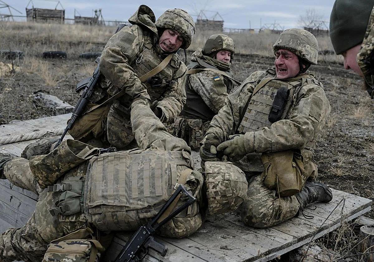 Dos miembros de una brigada paracaidista ucraniana arrastran a un compañero herido