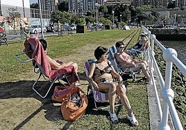 Varias mujeres en una foto de archivo tomando el sol junto a la dársena, una zona «infrautilizada».