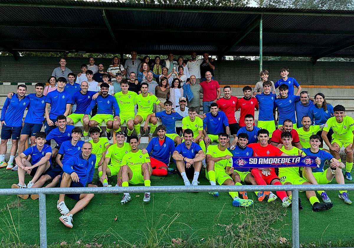 La plantilla y cuerpo técnico del Amorebieta, junto a varios aficionados, celebran la victoria lograda en Sámano