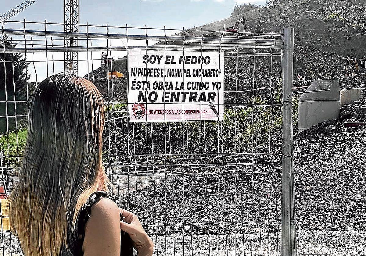 Una vecina observa el cartel colocado por el hijo de 'El Cachabero' en una obra.