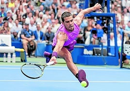 Carlos Alcaraz se estira para devolver una pelota en un partido en el que despachó en solo tres sets a uno de los mejores tenistas de la historia