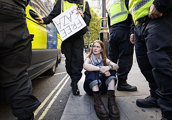 Agentes de policía arrestan a una partidaria de Palestine Action que asistía a una protesta masiva organizada por el grupo Defend Our Juries en Londres.