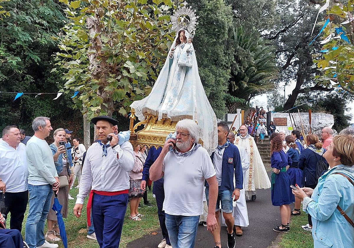 Una comitiva con trajes de arrantzal y remos dio paso a la Virgen del Socorro, en el centro de todas las miradas, a la salida de la ermita.