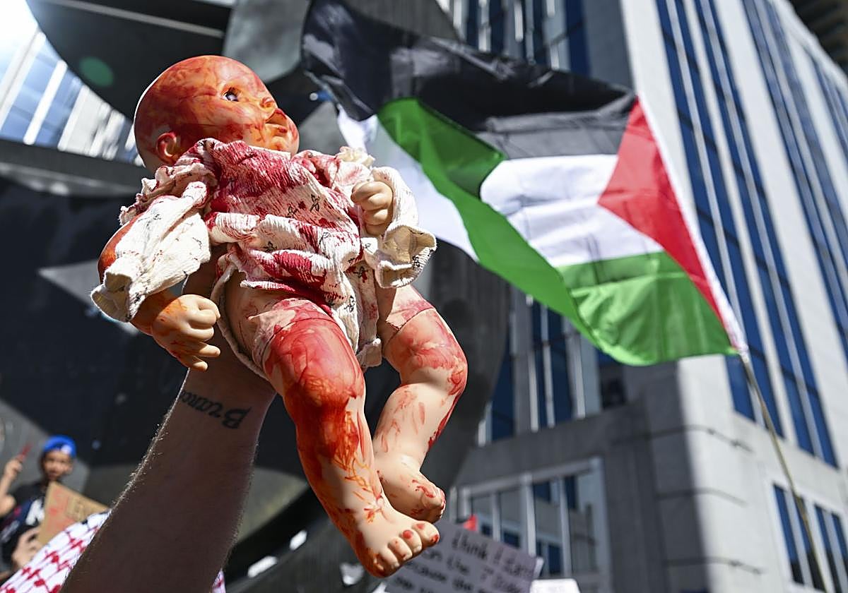 Una persona levanta una muñeca pintada de rojo como parte de la protesta «Dibuja la línea roja para Gaza» contra las operaciones militares de Israel en la Franja de Gaza y en apoyo al pueblo palestino, en Bruselas.