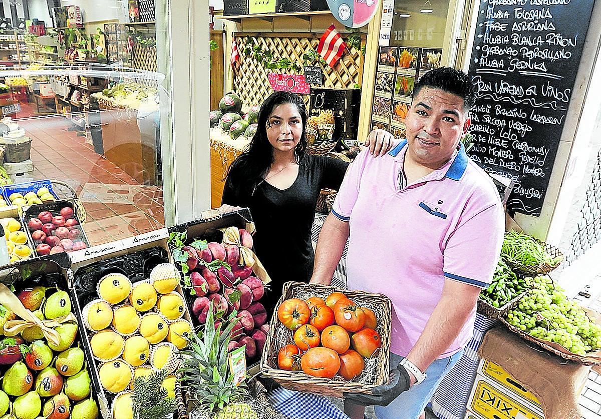John David Rojas posa con una parte del género que vende en su tienda