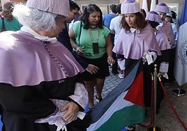 Unas profesoras llevan una bandera palestina a la llegada a acto de apertura oficial del curso académico de las universidades andaluzas.