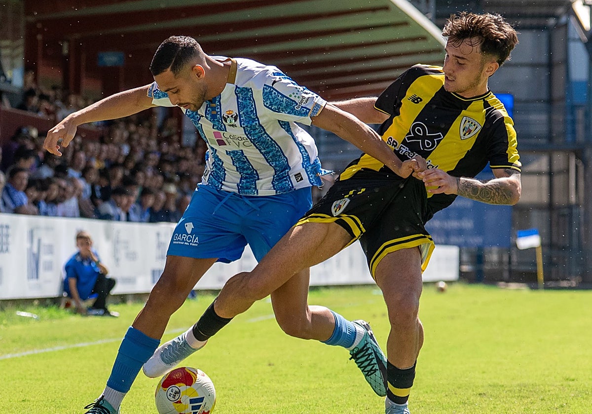 Eric Pérez trata de robar un balón a un jugador del CF Talavera de la Reina.