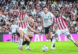 Sancet e Iñaki Williams buscan un balón entre la defensa del Valencia.