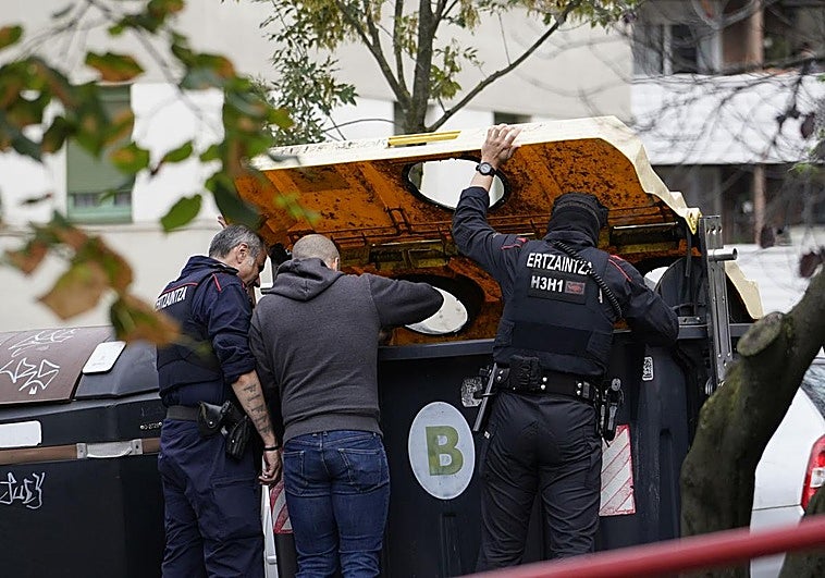 Investigadores de la Ertzaintza tratan de localizar el arma homicida en un contenedor.