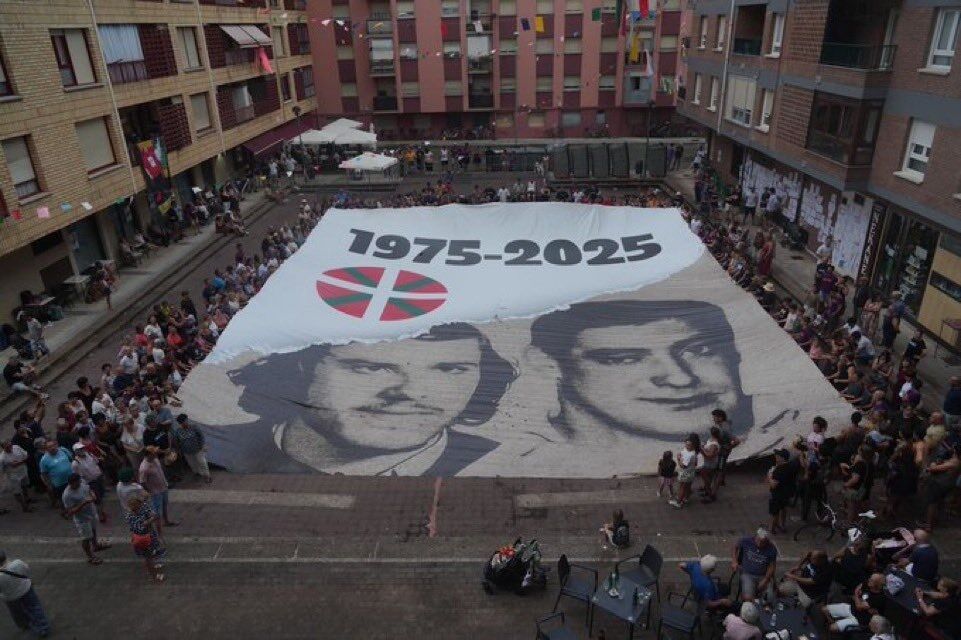 Una plaza de Zarautz, con un gigantesco mural de 'Txiki' y Otaegi.
