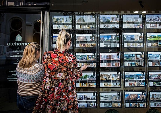 Dos mujeres observan los anuncios de una inmobiliaria en Bilbao