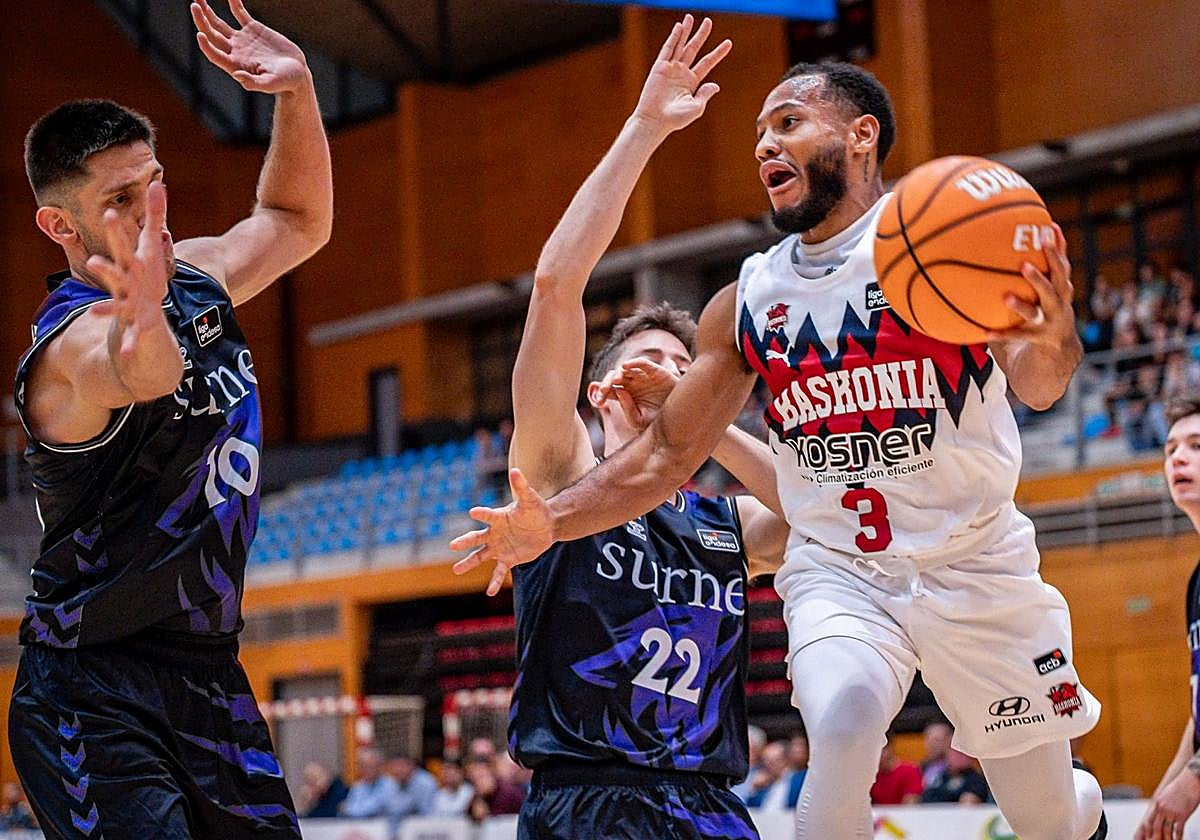 Nowell busca un pase ante dos jugadores del Bilbao Basket.