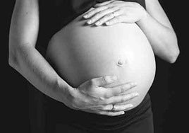 Mujer embarazada posa en una foto de estudio