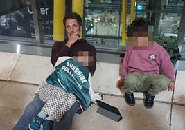 Un padre trata de dormir a uno de sus pequeños, en el suelo de Barajas.