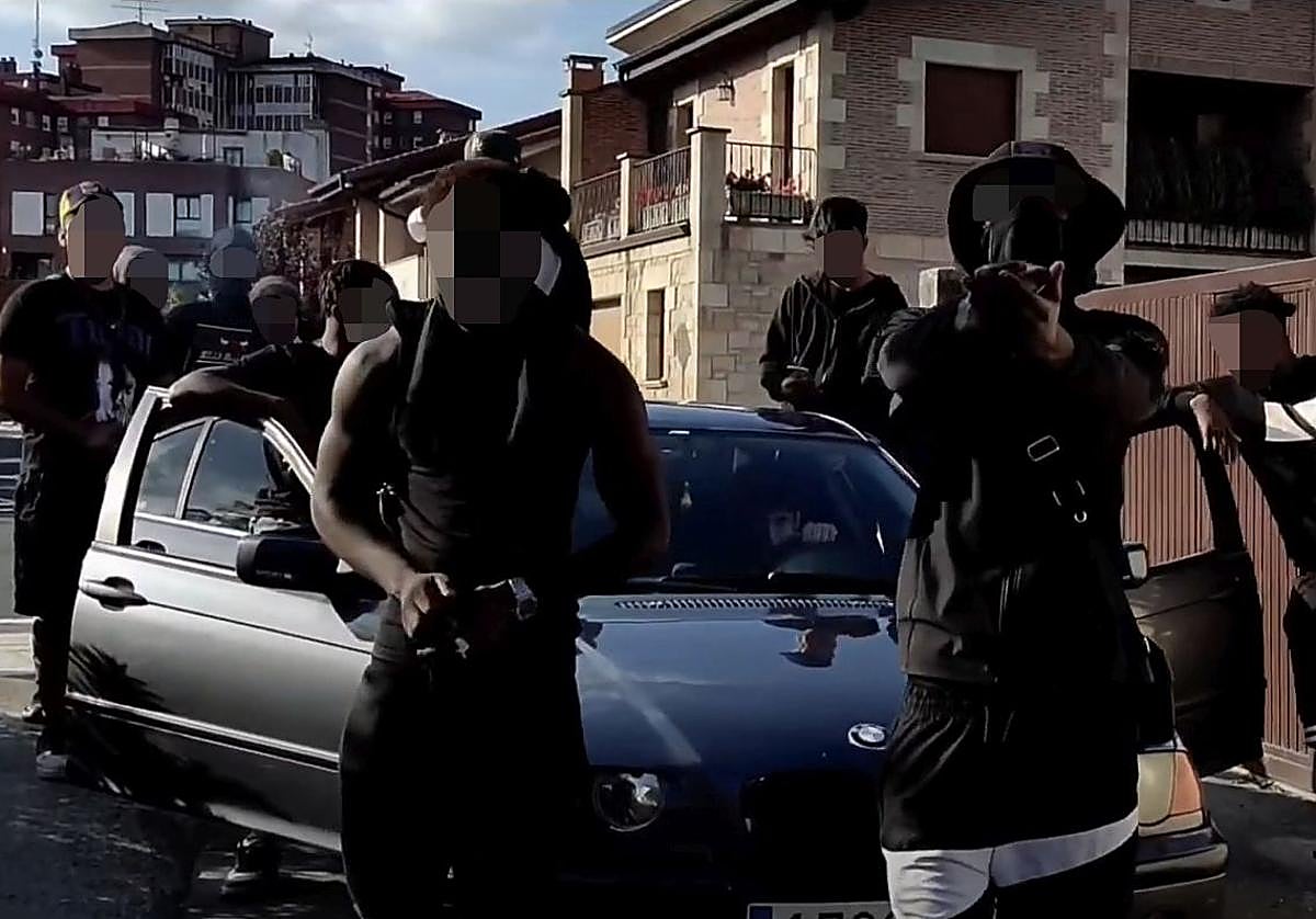 Supuestos componentes de la banda 015 posan una calle del barrio de Ali con un coche de alta gama.