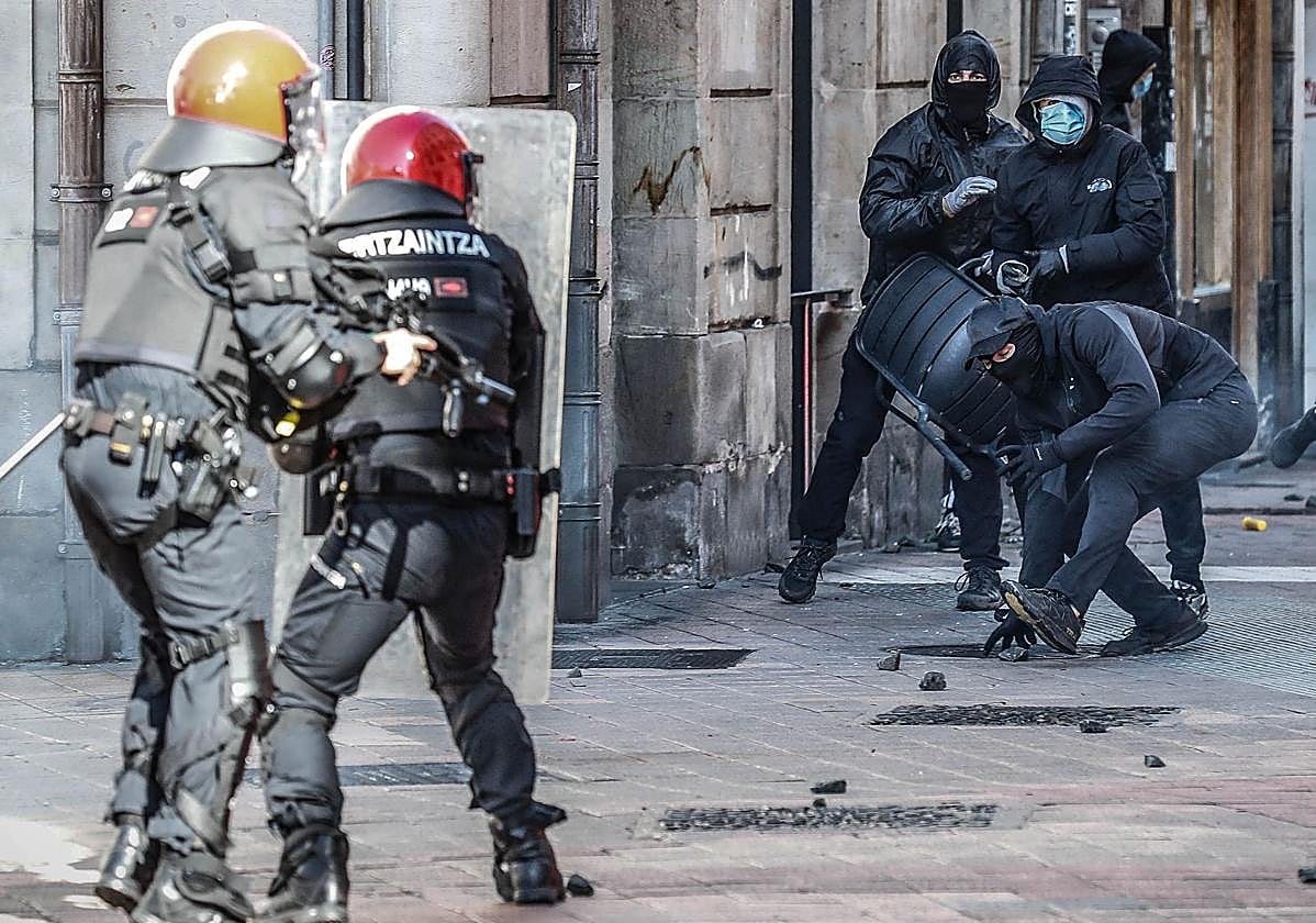 Varios radicales arrojan trozos de adoquines a una pareja de agentes de la Ertzaintza.