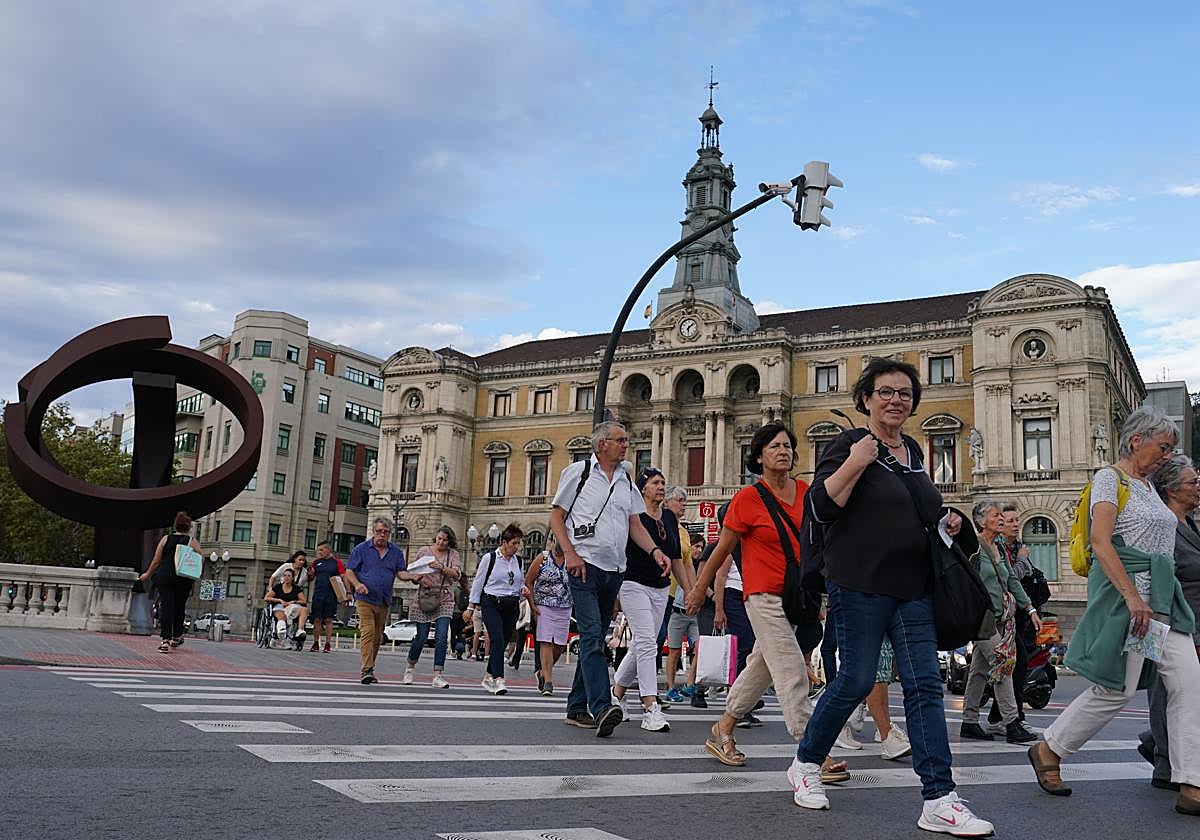 Un grupo de personas pasa por delante del Ayuntamiento de Bilbao.