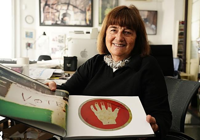 La artista muestra el libro sobre Lemoiz con la señal de la mano que se desintegra.