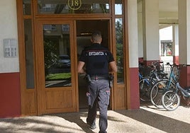 Un agente entra en el portal de la calle Indamendi.