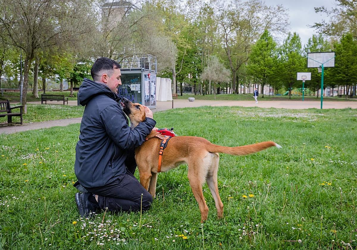 Un joven juega con su perro en el parque de Judimendi.