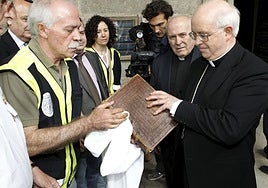 El jefe de la Brigada de Patrimonio Histórico de la Policía Nacional en 2012, Antonio Tenorio, entrega al arzobispo de Santiago, Julián Barrio, el Códice Calixtino recuperado tras el robo.