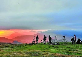 Un grupo de ornitólogos otean el horizonte a la espera de bandadas de pájaros de camino al sur.
