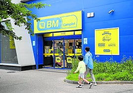 Una madre y un niño caminan frente a uno de los muchos supermercados BM que el Grupo Uvesco tiene abiertos en Euskadi.
