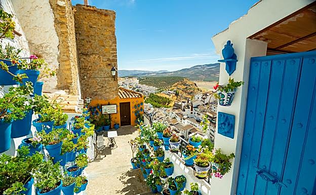El color azul de puertas y macetas alegra las callejuelas como esta a los pies de la Torre de San Rafael.