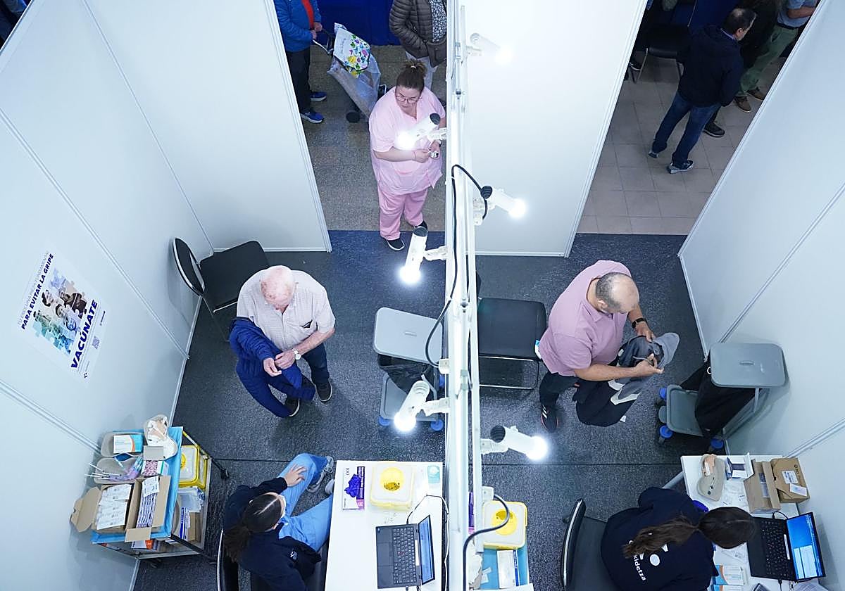 Dos personas se disponen a recibir el suero antigripal en el vacunódromo habilitado en La Casilla.