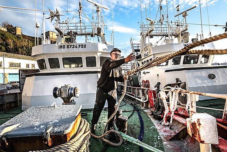 Un marinero lanza el cabo para amarrar en el puerto de Ondarroa uno de los barcos de altura.