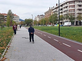 Unos vecinos caminan por la zona verde del bidegorri de Landako