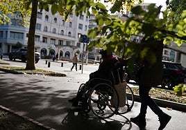 Una mujer y su cuidadora pasean por el centro de Bilbao.